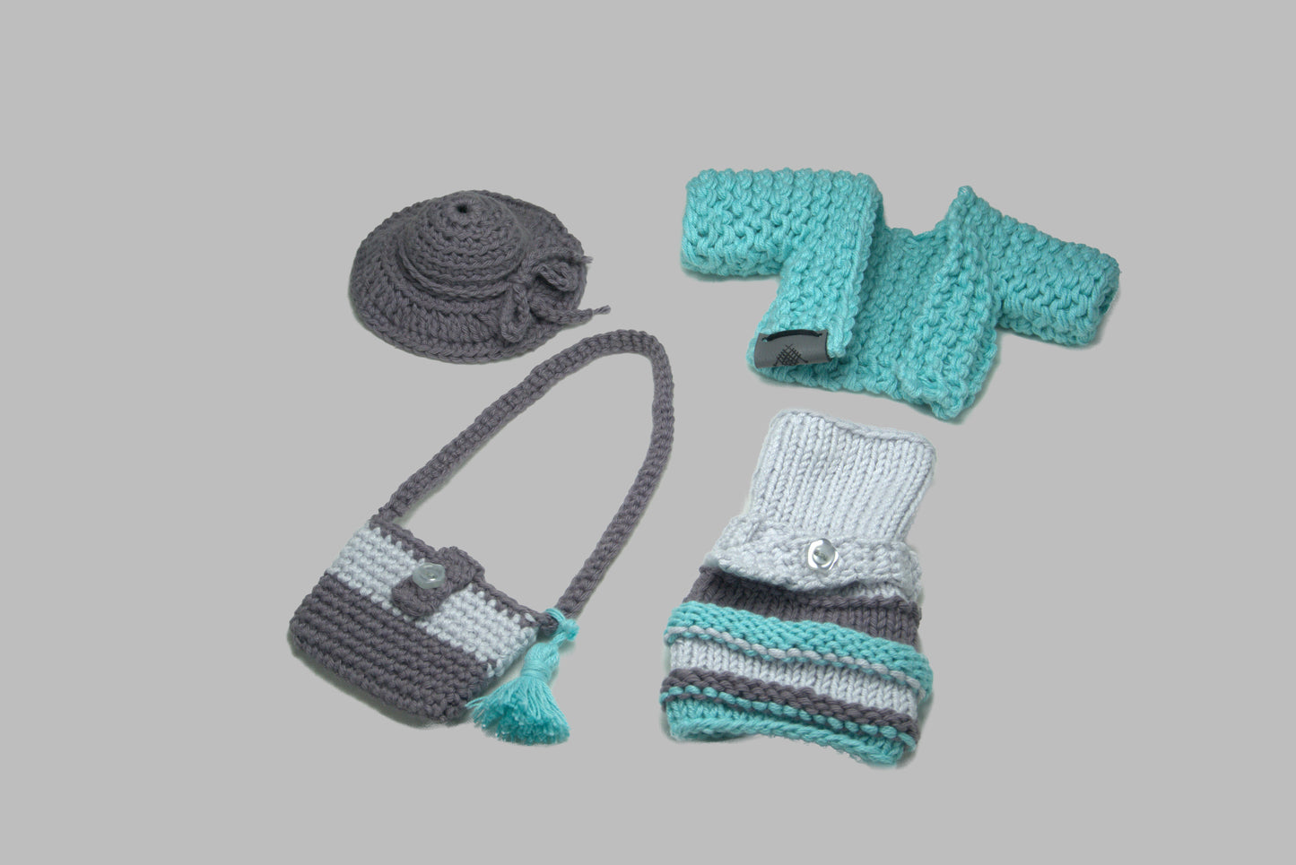 Gestricktes Barbie-Outfit in Grün und Grau, bestehend aus Mantel, Kleid, Tasche und Hut – handgefertigte Kleidung für Puppen.