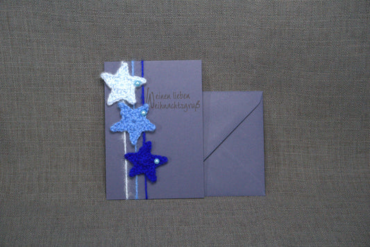Handgefertigte Grußkarte in Blau mit gehäkelten Sternen aus 100% Wolle. Doppelkarte im DIN A6-Format mit passender Briefhülle in Blau – einzigartig & stilvoll.