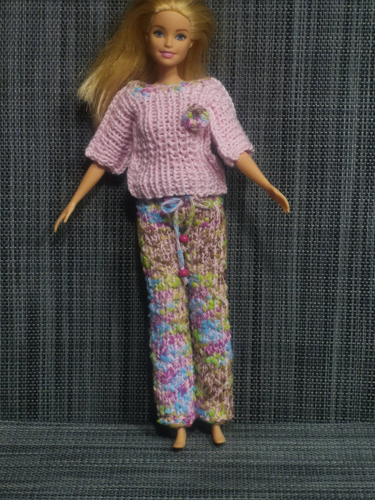 Gestricktes Barbie-Outfit in bunten Farben, bestehend aus Pulli und Hose – handgefertigte Kleidung für Puppen.