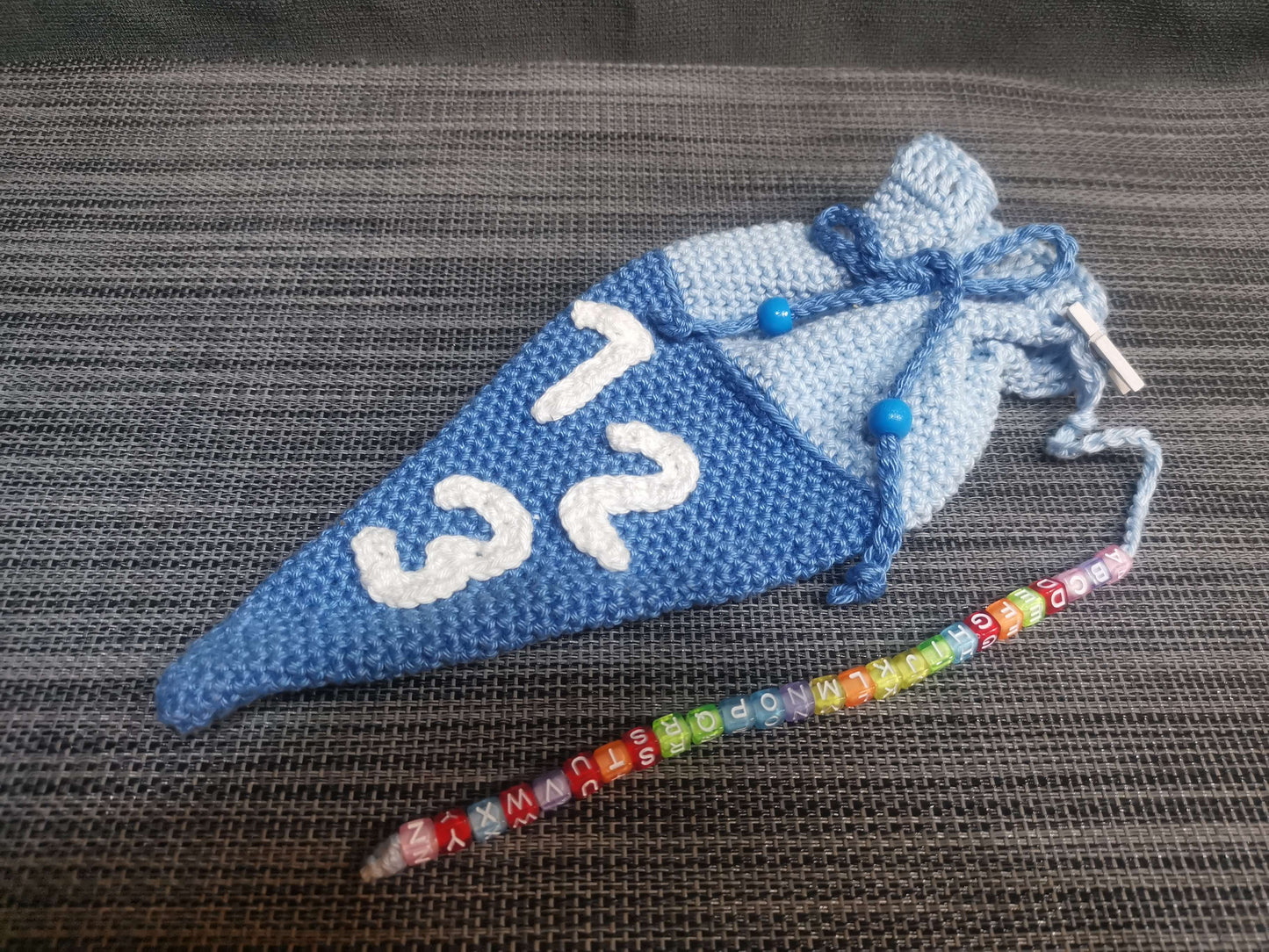 Handgehäkelte Mini-Schultüte in Blau mit ABC-Kette, 23 cm hoch, 10 cm breit – Einschulungsgeschenk von bw-handmade.